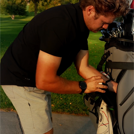 Golfer storing the Mulli-Can in the large zippered pocket of a golf bag